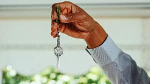 a man holding a key in a house for sale in melbourne